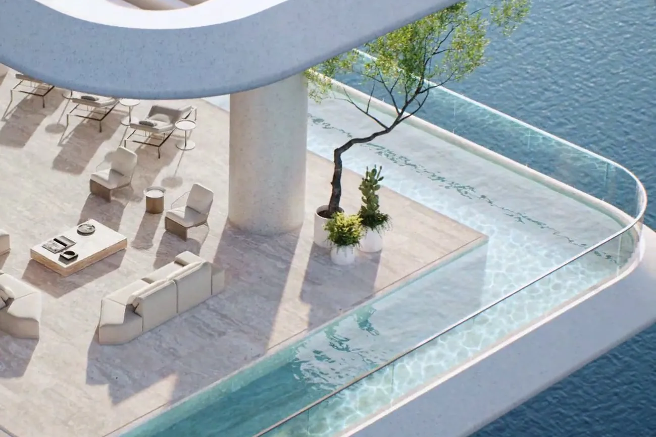 Private terrace with lounge seating wrapped by a glass-edged corner pool